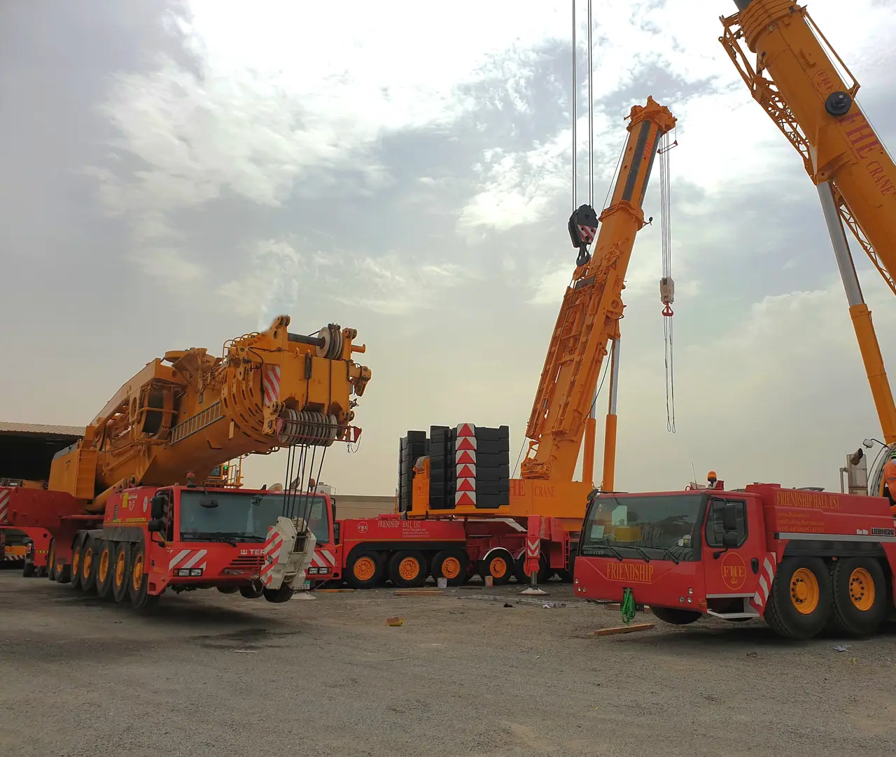 FHE fleet of red and yellow all-terrain cranes in the yard