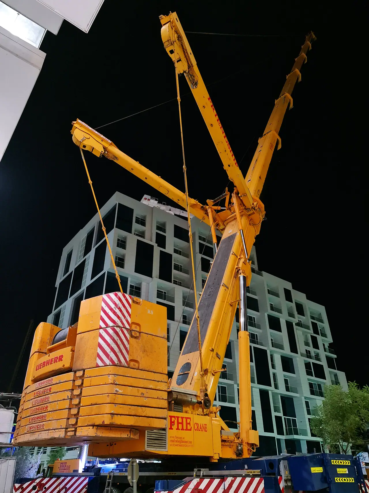FHE heavy crane with superlift counterweight working at night